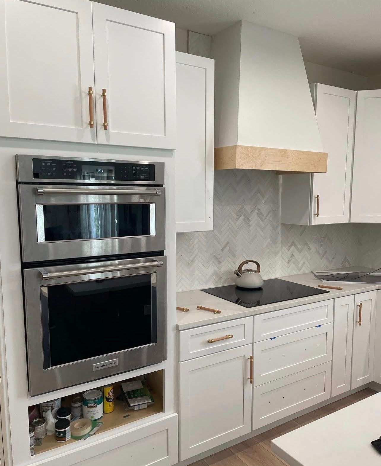 Shaker kitchen with custom hood and herringbone backsplash
