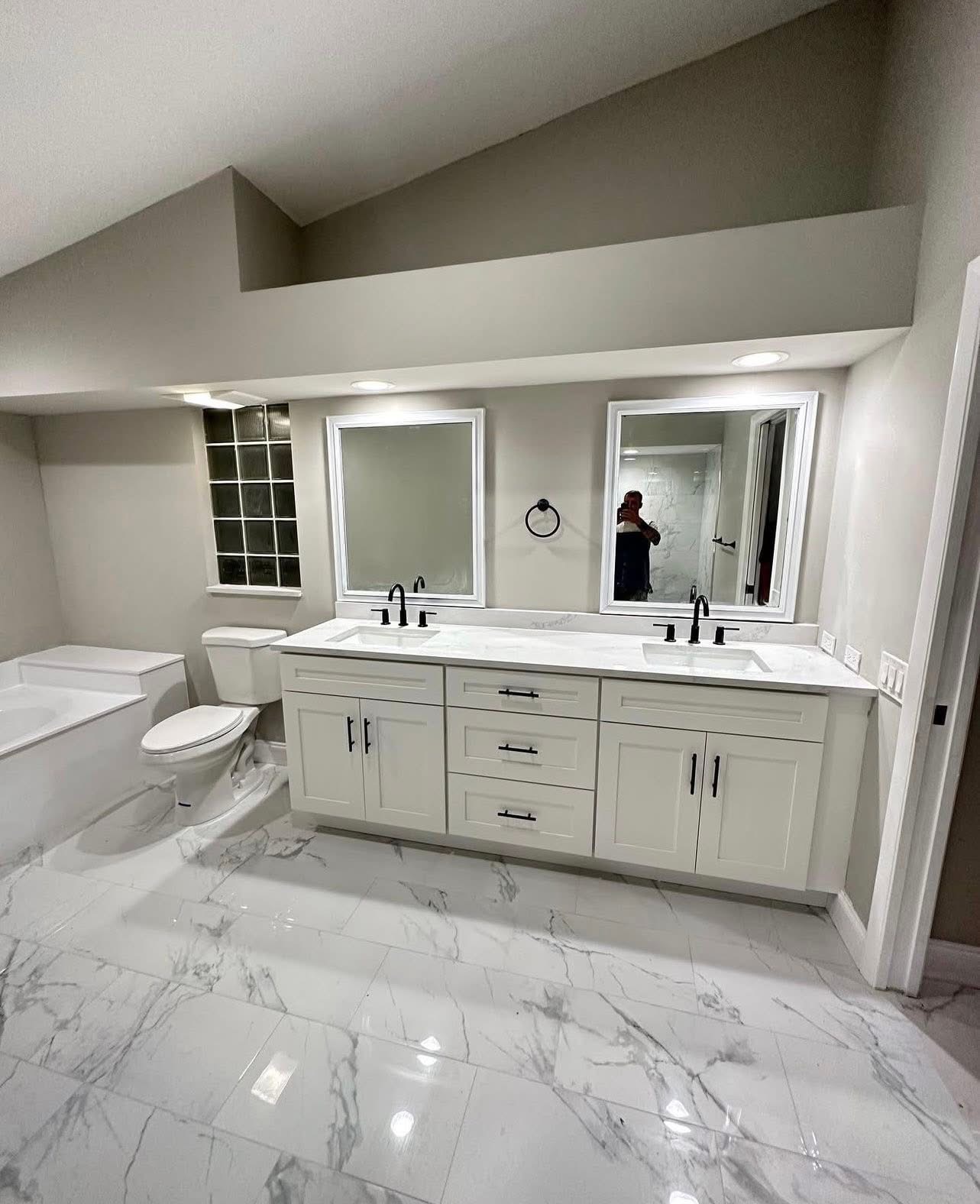 Master bath with double floating vanity and vaulted ceiling