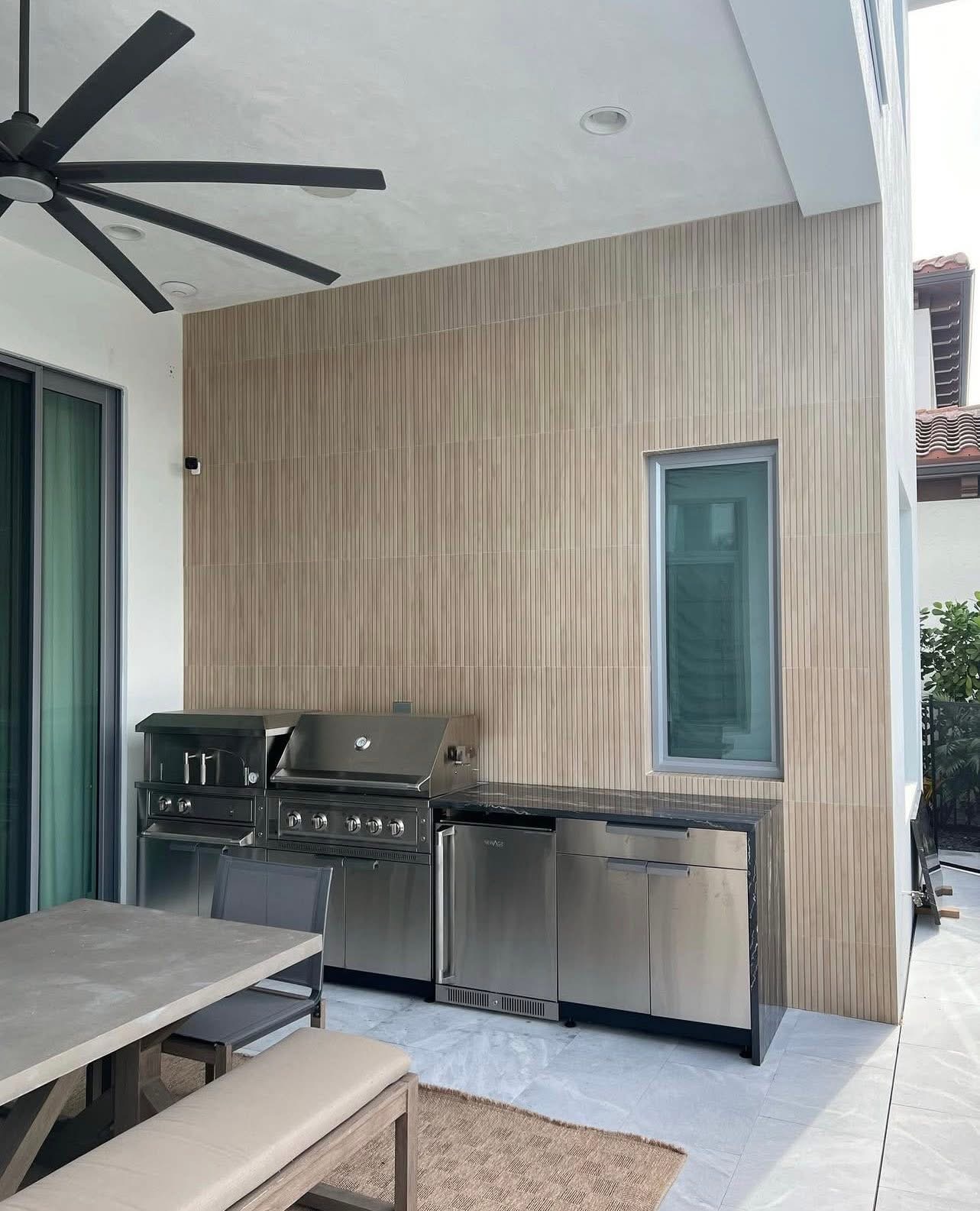 Outdoor kitchen with fluted tile wall and stainless grill