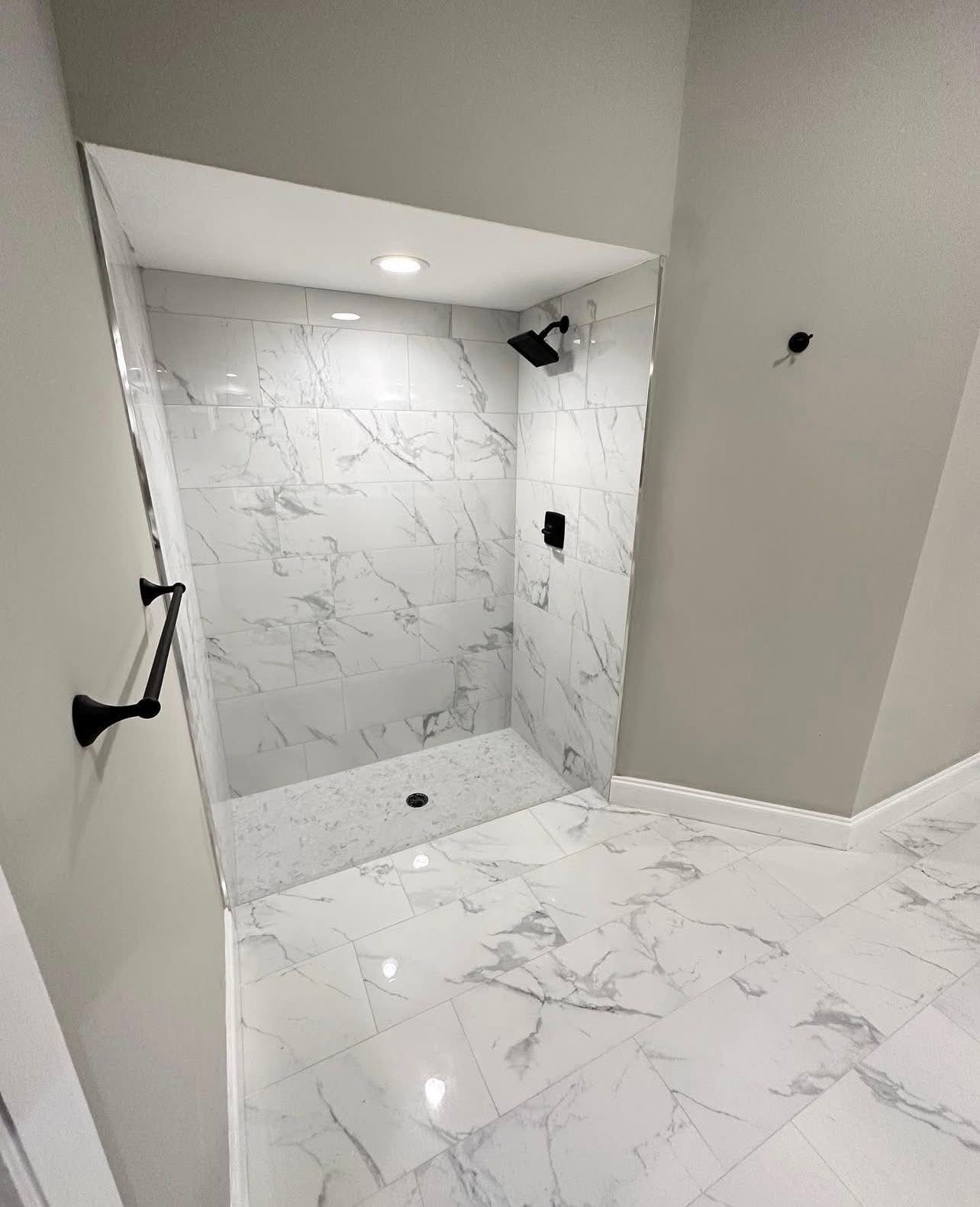 Walk-in marble shower with matte black fixtures